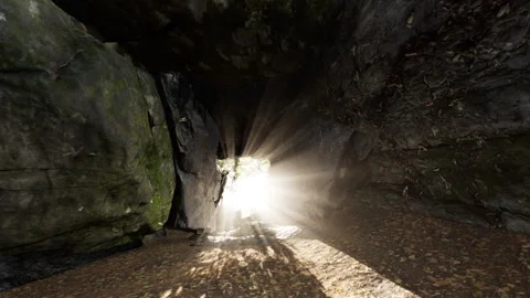 Shaft of light beaming down into large cave Stock Footage 246604656