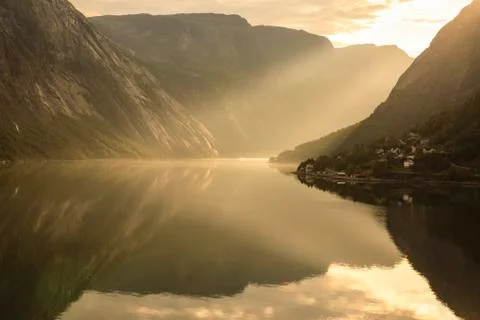 Shafts of light enter misty, beautiful Eidfjord, fjord reflections, Stock Photos