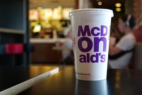 Shake on the table and people inside McDonalds fast food restaurant in Kyiv c Stock Photos