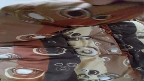Shaking and moving a brown patterned duvet blanket on a bed first person view Vídeos de archivo 335397982