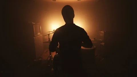 Shaking camera, drummer silhouette, in the dark room opposite the searchlight Stock Footage 105455036