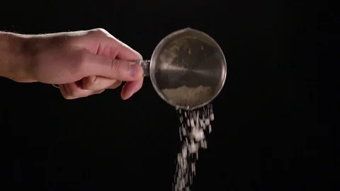 Shaking Flour From Measuring Cup In Slow Motion Against Black Background Stock Footage 82149101