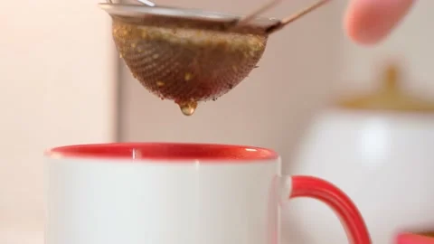Shaking a green tea stack over a cup of brewed tea Stock Footage 200197911