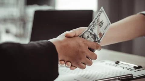 Shaking hands with congratulations on an evil plan, Businessmen give dollars Stock Photos