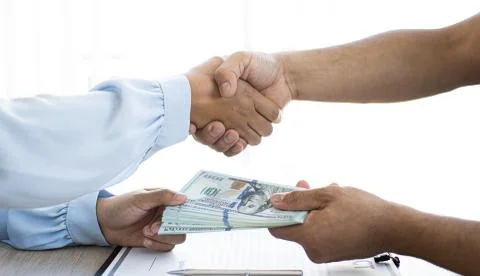 Shaking hands with congratulations on an evil plan, Businessmen give dollars Stock Photos
