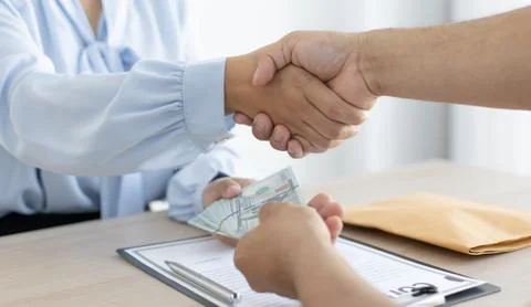 Shaking hands with congratulations on an evil plan, Businessmen give dollars Stock Photos