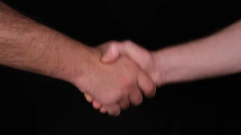 Shaking hands, two men shaking hands on black background Stock Footage 167354017