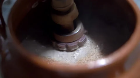Shaking hot cocoa in a clay pot with Mexican molinillo Stock Footage 148509948