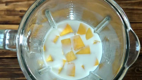 Shaking mango smoothie in blender, top view slow motion video Stock Footage 89488726