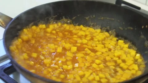 Shaking pumpkin risotto to mix with rich sauce while cooking Stockbeeldmateriaal 151970285