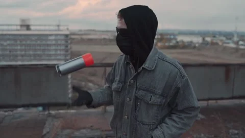 Shaking a red spray paint can on the abandoned roof. Punk graffitist Stock Footage 143793432