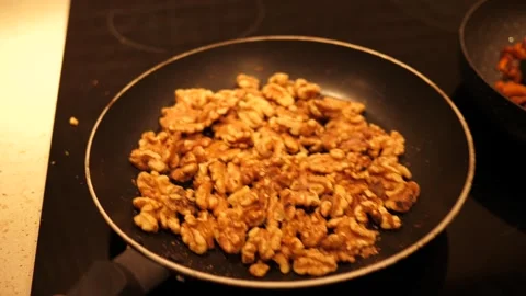 Shaking walnut on a frying pan - cooking at home Stock Footage 287017908