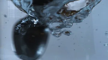 Shaking the water in a glass container, slow motion Stock Footage 85534765