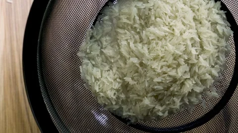 Shaking wet basmati rice inside black metal sieve top view macro, 4K 스톡 동영상 342512946