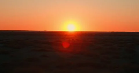 Shaky Driving Shot of Red Sun Over Desert Road at Sunset Stock Footage 321771702