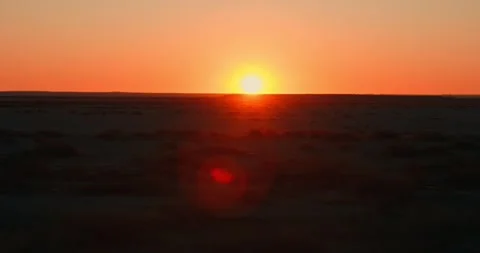Shaky Driving Shot of Red Sun Over Desert Road at Sunset Stock Footage 321771749