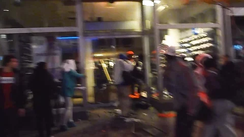 Shaky intense immersive shot inside a riot during the looting of a shoe store Stock Footage 127123467