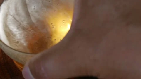 A shaky POV of a man placing a beer on a table. A large glass of draft beer Vidéo 344773441