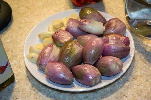 Shallots and garlic hulled and prepared on a plate 스톡 사진