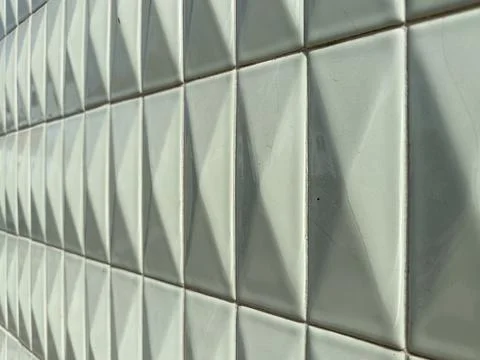 A shallow angle view of white ceramic tiles with a raised diamond relief pa.. Stock Photos