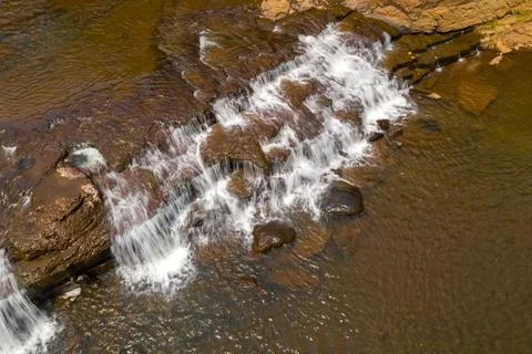 Shallow cascade over reddish rocks, Tad Tayicsua Stock Photos