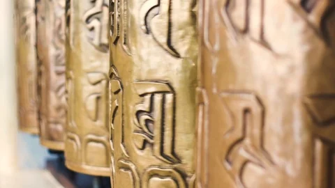 Shallow depth of feild of bhuddhist prayer wheel inscribed with a sanskrit Stock Footage 114653717