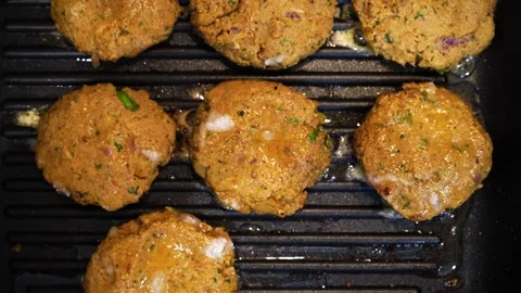 Shallow depth of feild shot mince meat mutton patties keema roasting on a pan Stock Footage 132638394