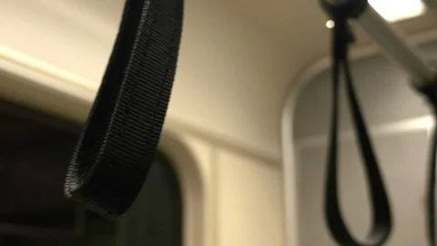 Shallow depth-of-field, close-up of hand grip, strap on commuter train. Stock Footage 107950597