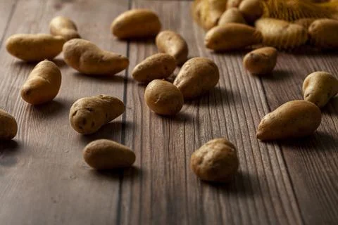 Shallow depth of field dark image of small irregular shaped ratte potatoes Stock Photos