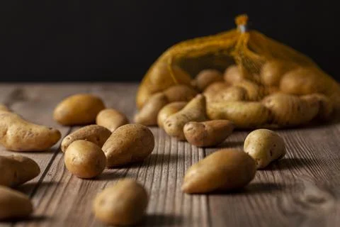 Shallow depth of field dark image of small irregular shaped ratte potatoes Stock Photos