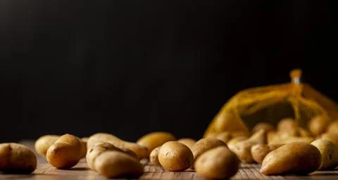Shallow depth of field dark image of small irregular shaped ratte potatoes Stock Photos