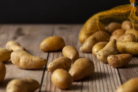 Shallow depth of field dark image of small irregular shaped ratte potatoes Stock Photos