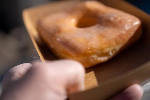 Shallow Depth of field image of a man holding a doughnut Stock Photos