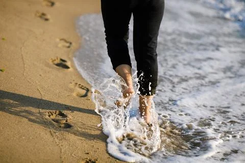 Shallow depth of field (selective focus) details with a woman walking barefoo Stock Photos