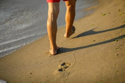 Shallow depth of field (selective focus) details with a man walking barefoot  Stock Photos