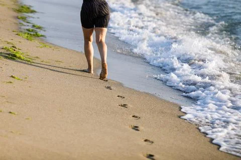 Shallow depth of field (selective focus) details with a woman jogging barefoo Stock Photos