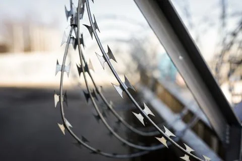 Shallow depth of field (selective focus) image with razor wire. Stock Photos