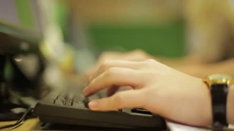 Shallow depth of field of young male hands typing on a black keyboard at college Stock Footage 297370853