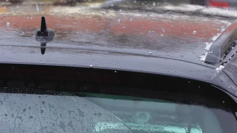 Shallow falling and jumping hail with rain on the roof of a car standing outside Stock Footage 126827459