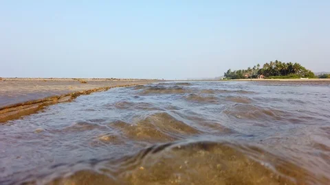 Shallow fast river surface and a beach house among the coconut trees Stock Footage 128843936