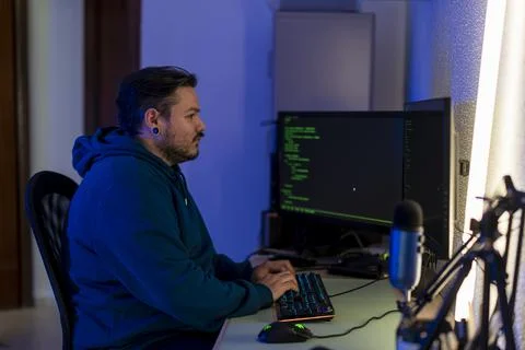 Shallow focus of a computer programmer working in front of two computer monitors 스톡 사진