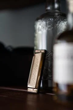 Shallow focus shot of a harmonica and glass bottles on the bar counter Stock Photos