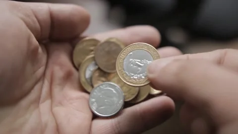 Shallow focus shot from a man counting Brazilian Real coins in his hands Video stock 209713217