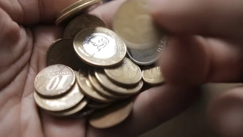Shallow focus shot from a man counting Brazilian Real coins in his hands Video stock 209713285
