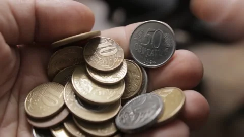 Shallow focus shot from a man counting Brazilian Real coins in his hands Stock Footage 209713316