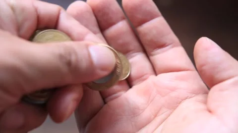 Shallow focus shot from a man counting brazilian real coins on his hands Stock Footage 279463526