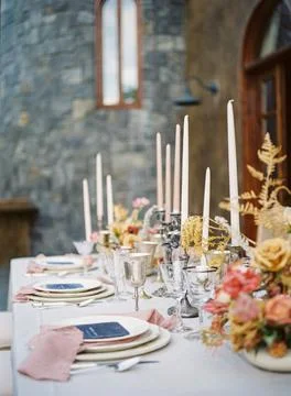 Shallow focus shot of a reception table with ceramic dishes and candles chandeli Fotos de archivo