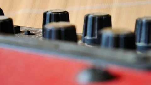 Shallow focus sliding view of tuning control knobs on red guitar amplifier 動画素材 100225730