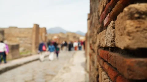 Shallow-focus view along a Pompeii street with ancient brick wall texture in Stock Footage 335276916