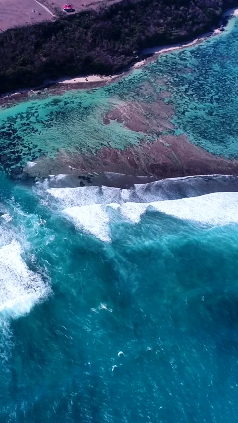 Shallow reef with deeper part, waves crashing and cliffs on coast Stock Footage 230299204